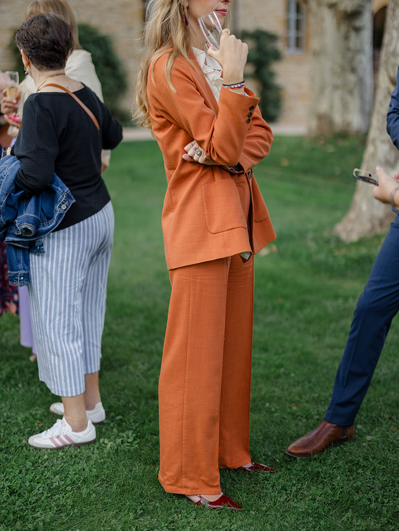0091-chateau-de-bagnols-wedding-france-wedding-guest-orange-suit